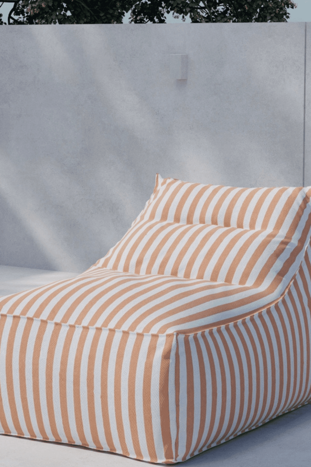Modern outdoor lounge chair with beige and white vertical stripes, featuring a soft, cushioned design perfect for relaxing in a sunny patio setting. The chair’s ergonomic shape offers comfort and style against a minimalistic concrete wall backdrop. | PicSEO 1773145590018
