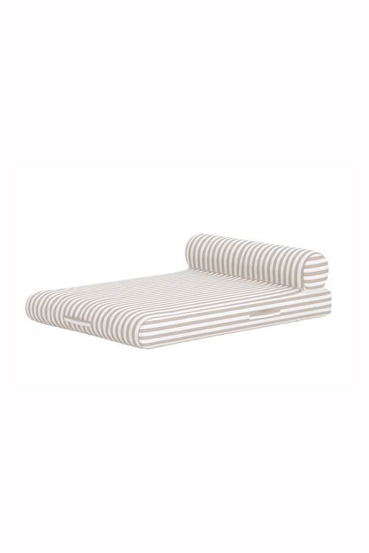 Modern beige and white striped pet bed with a cylindrical bolster pillow, featuring a low-profile design, soft cushioned surface, and convenient side handles for easy portability and stylish comfort. | PicSEO 1773144972594